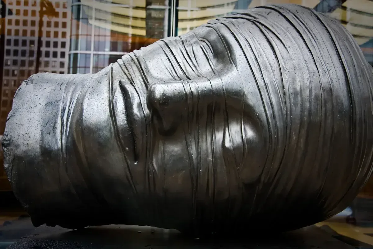 Igor Mitoraj Testa Addormentata bronze sculpture 1983, Canary Wharf, London — permanent public collection