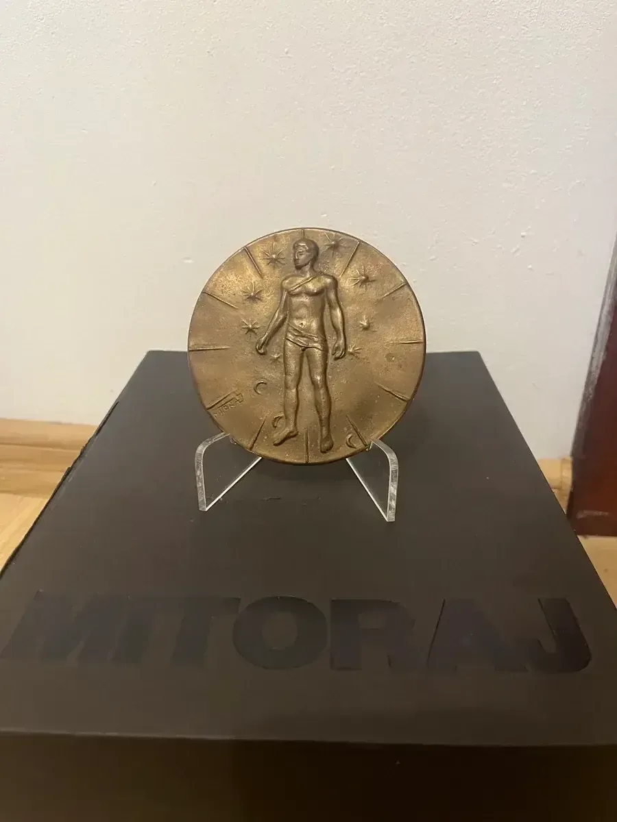 Mitoraj Articulations — bronze medal on stand with original Mitoraj catalogue, collector photograph