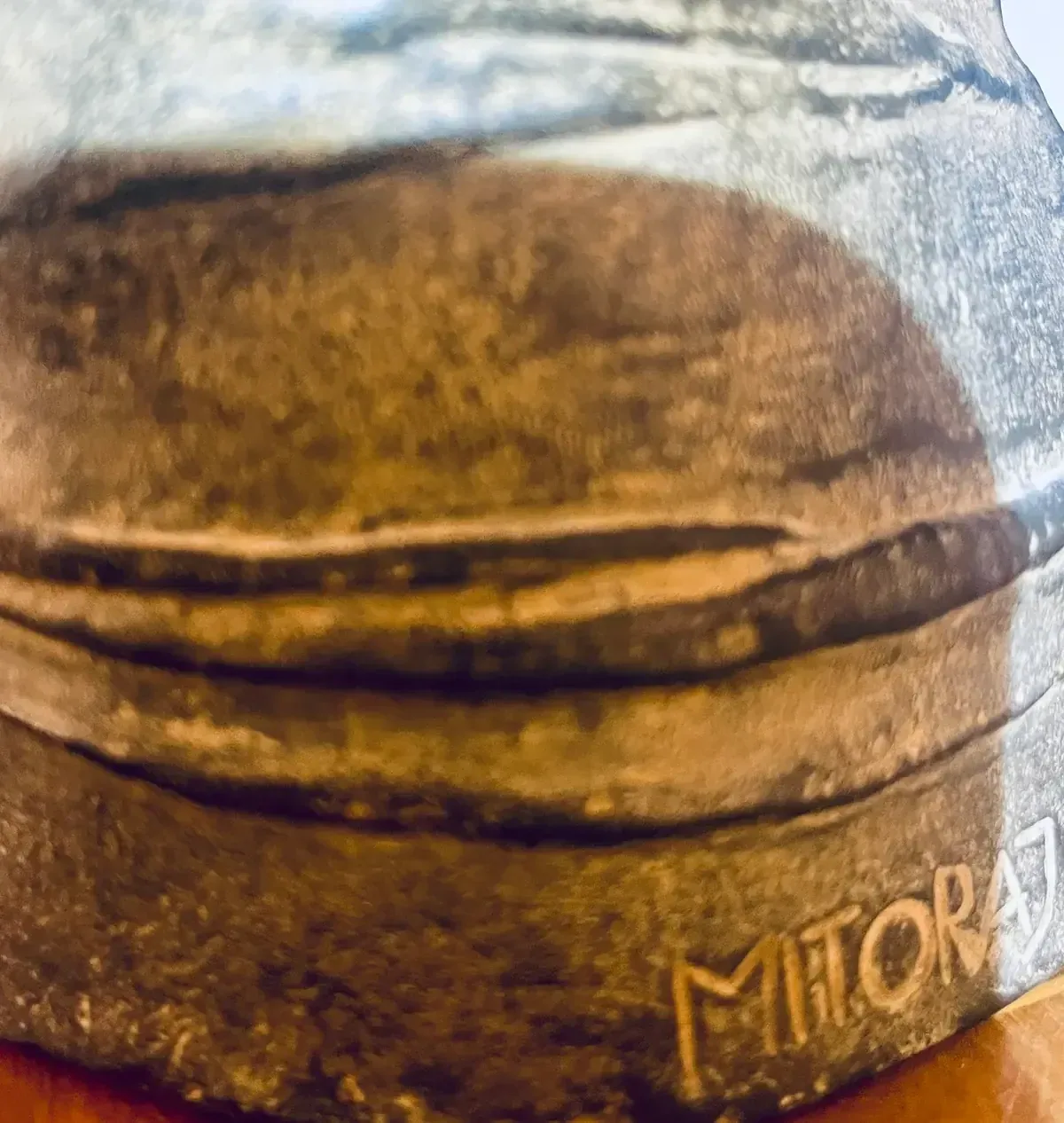 Corazza Media 1987 — Mitoraj signature close-up, dark patinated bronze surface detail