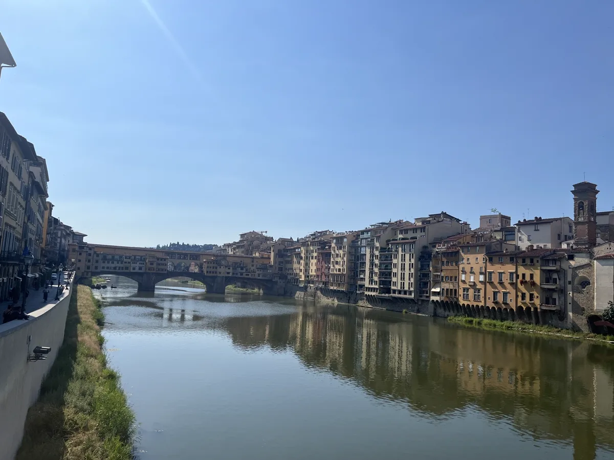 View of the Arno river and Ponte Vecchio from the north bank, Florence, July 2026 — a walk toward the Boboli Gardens where Igor Mitoraj's Tindaro Screpolato stands