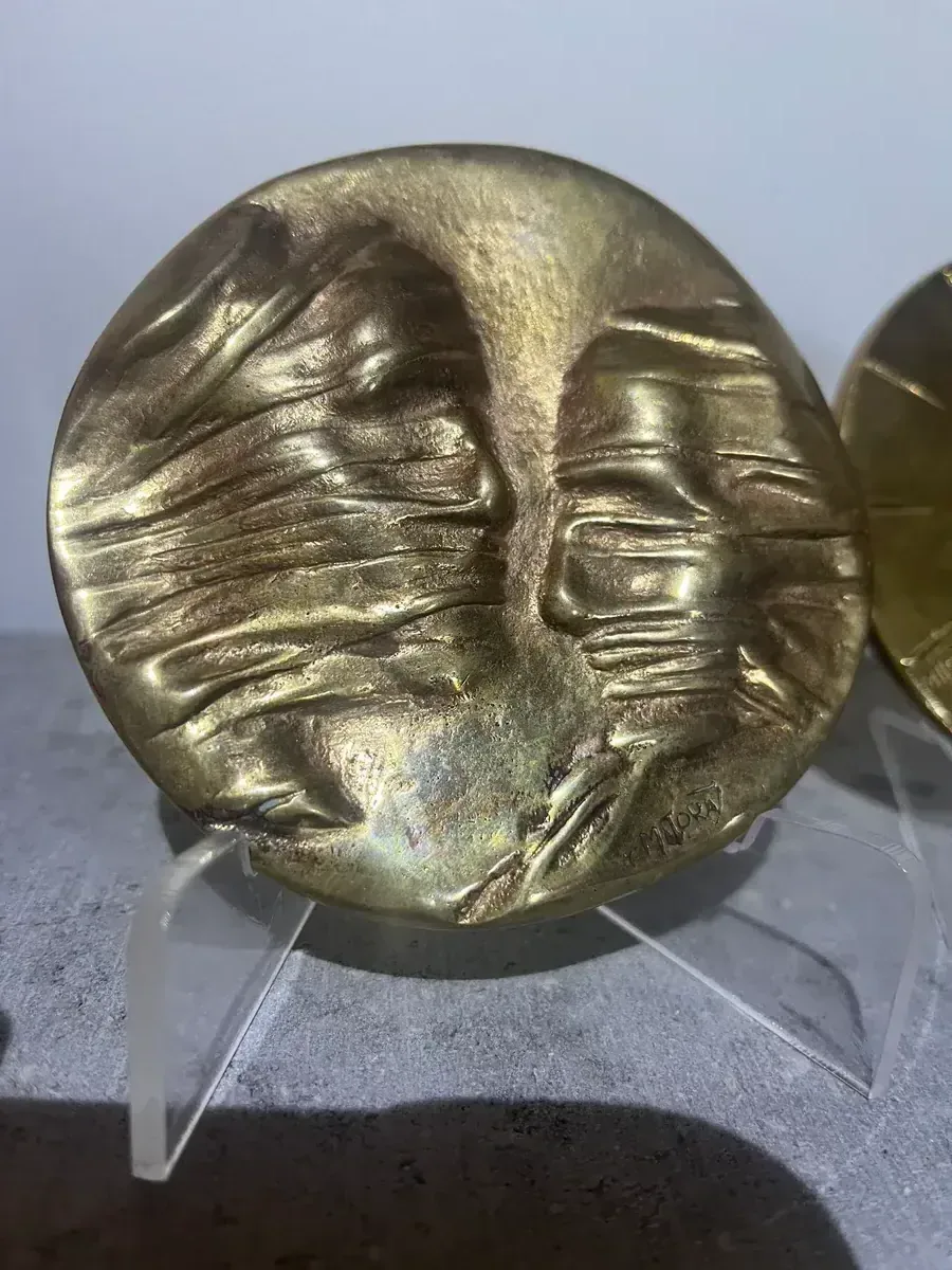La Conversation — Igor Mitoraj, obverse close-up showing two veiled profiles, Mitoraj signature — gold-patina bronze medal