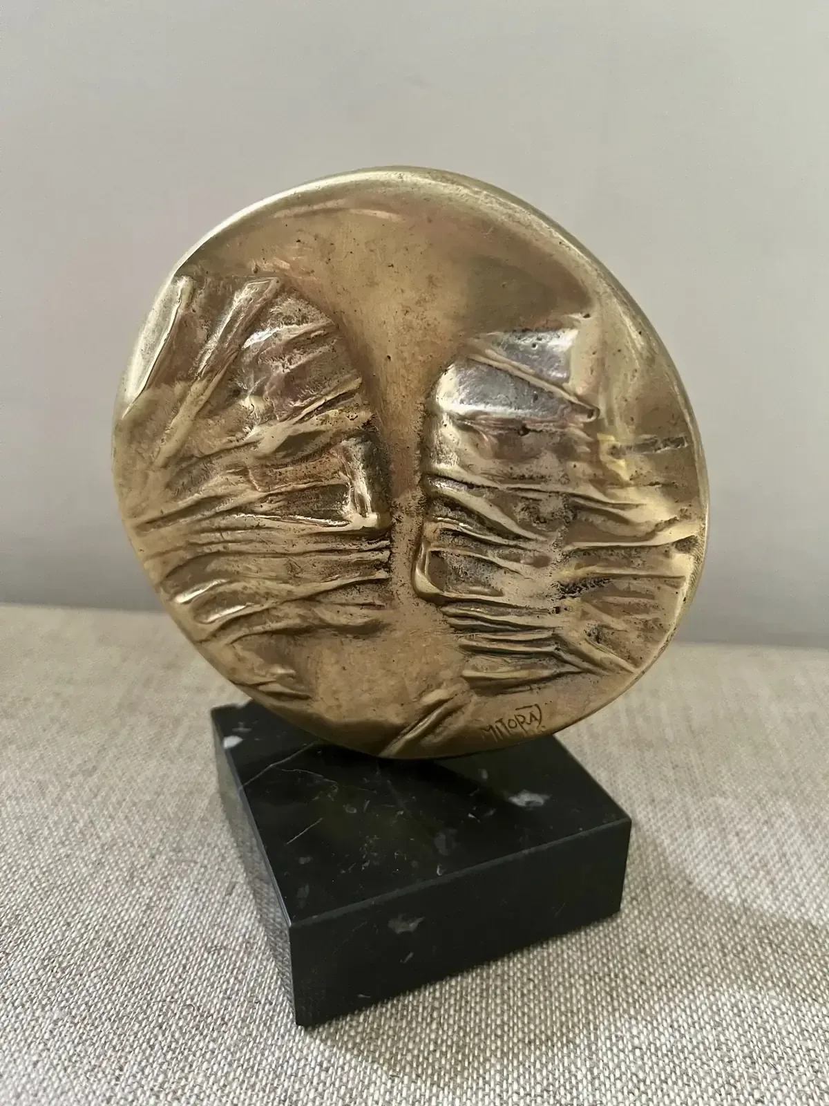 La Conversation — Igor Mitoraj, obverse showing two veiled profiles, warm gold patina on black marble base, front view