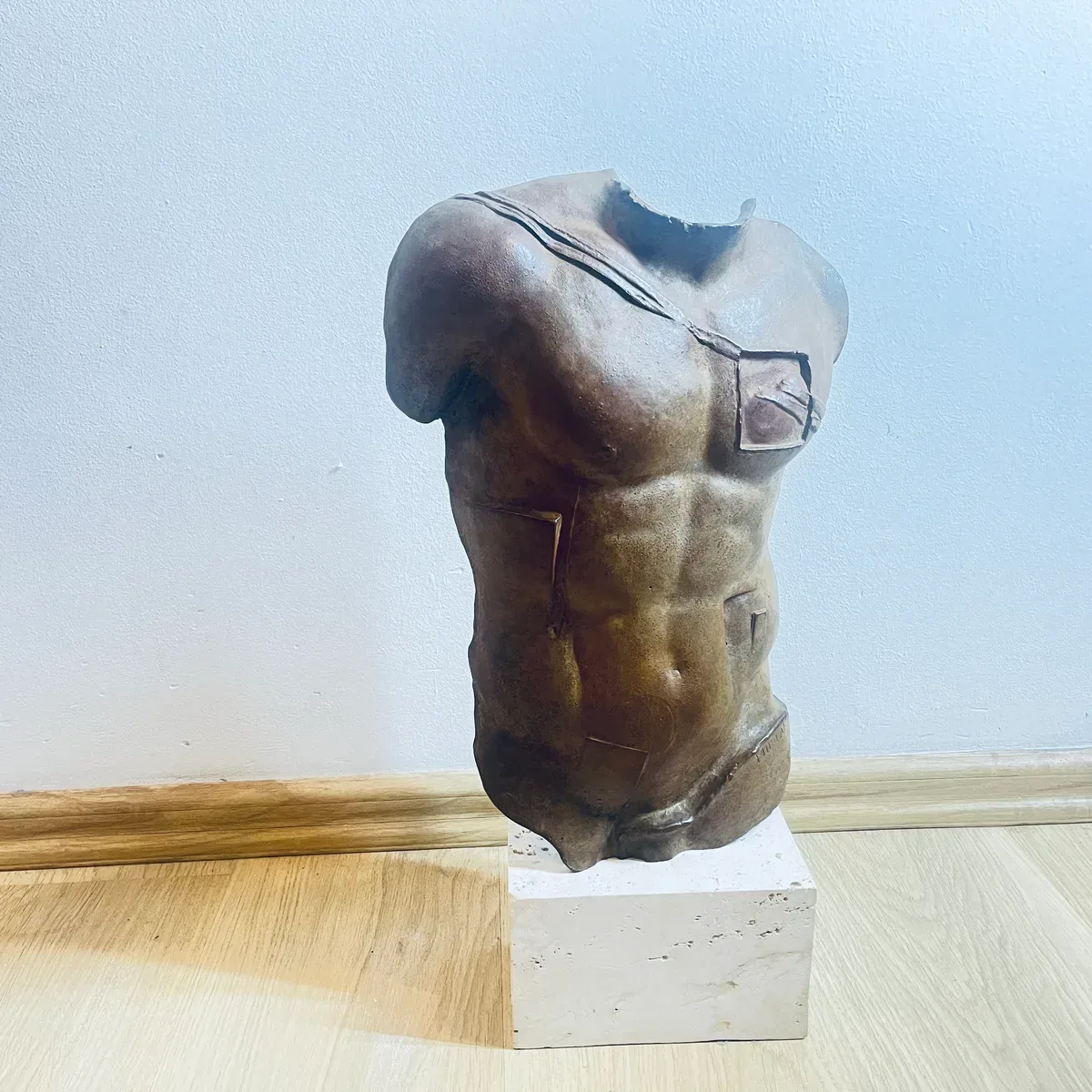 Persée (1988) — Igor Mitoraj, brown patina bronze torso, three-quarter view showing torn shoulder edge and chest inset, private collection