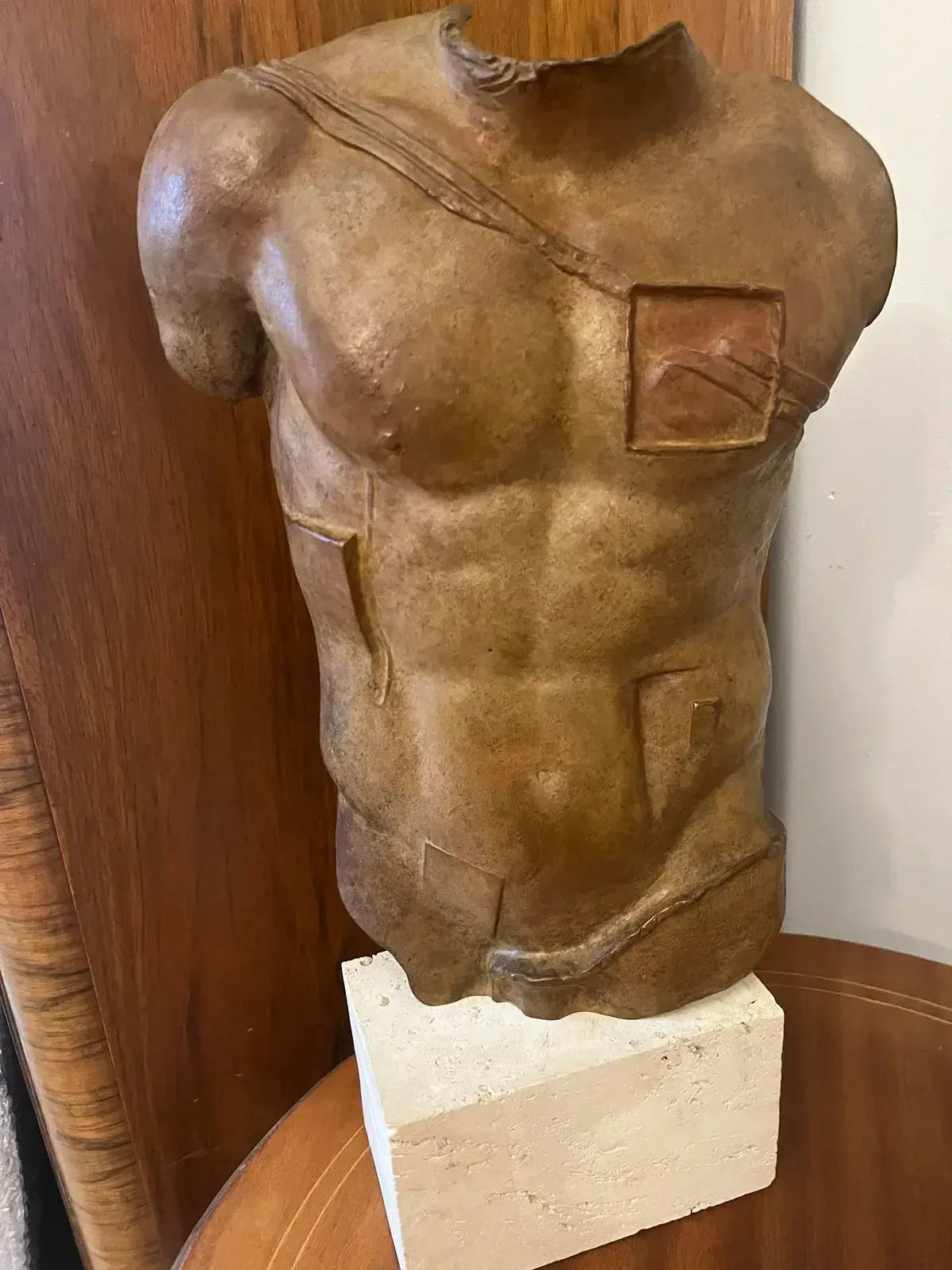 Persée (1988) — Igor Mitoraj, brown patina bronze torso laid on side, rear view showing travertine base, private collection