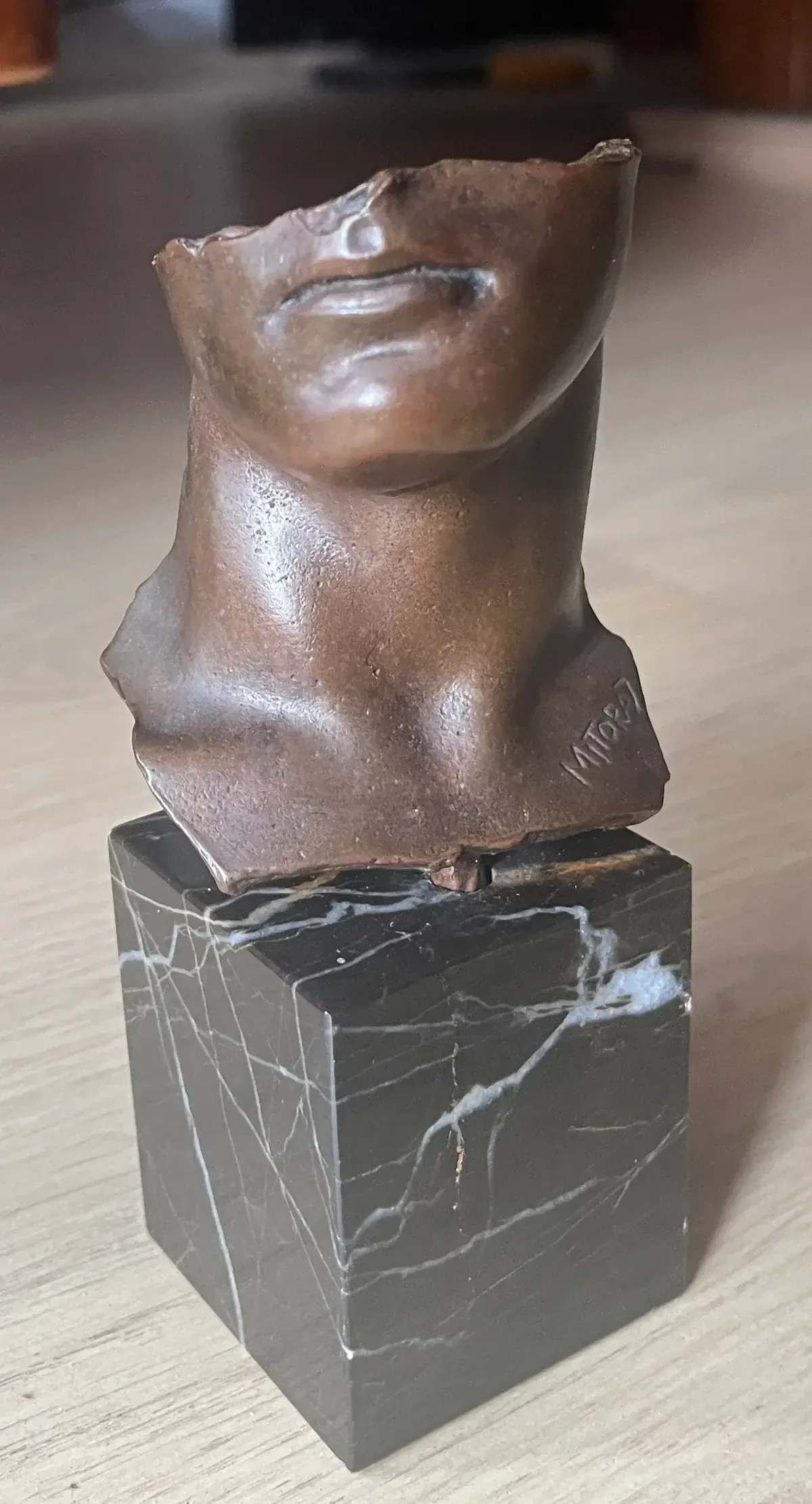 Portrait d'Homme (1984) — Igor Mitoraj, bronze, medal patina, close-up detail, warm amber background