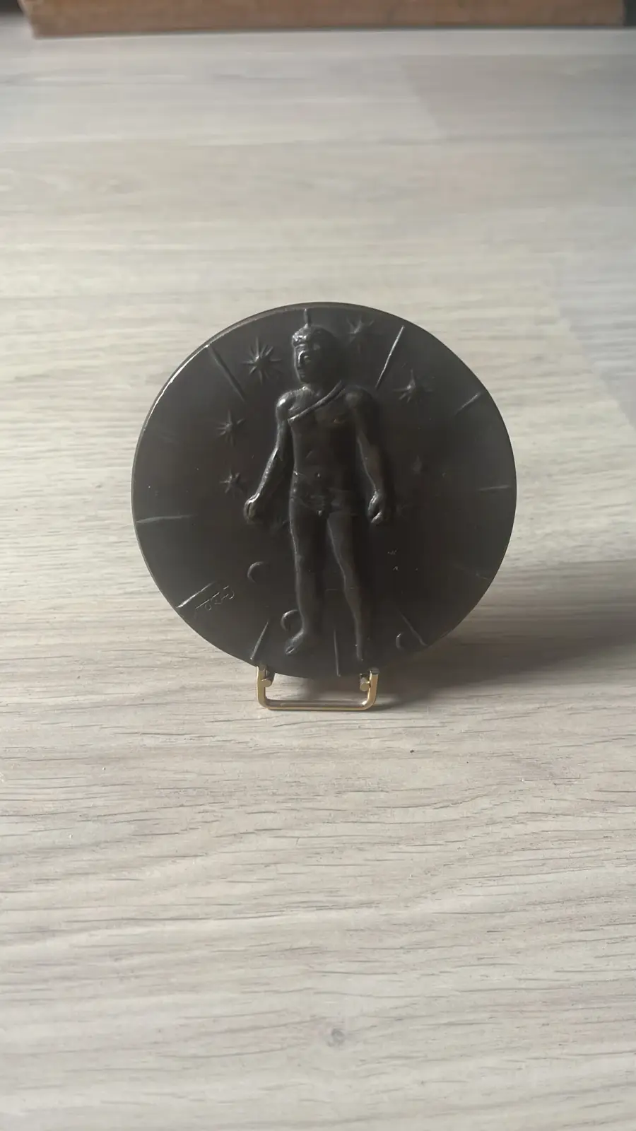 Okrągły medal Mitoraja — rewers z postacią związaną i gwiazdami