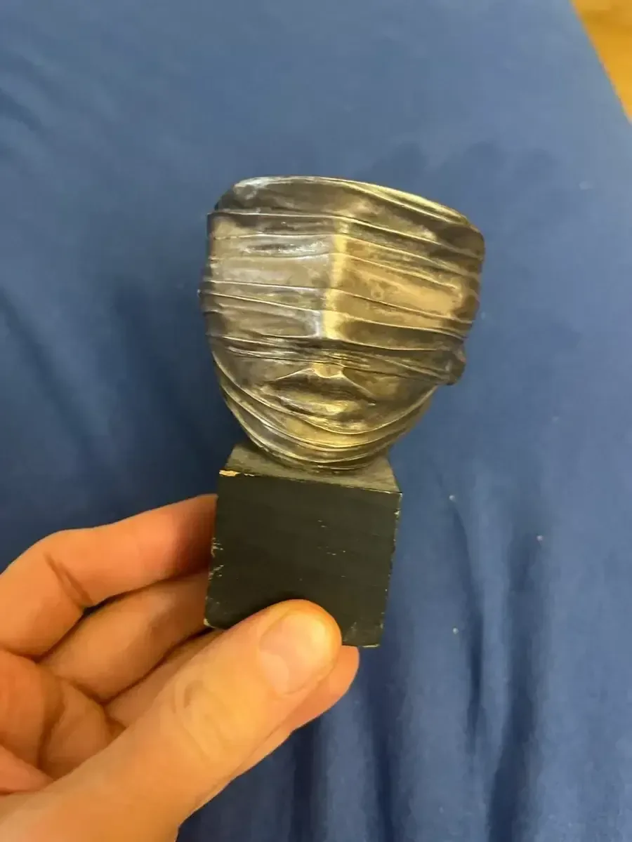 Visage Envoilé (c.1978) — Igor Mitoraj, silver-pewter patina bronze, angled view showing horizontal band, Ed. 250