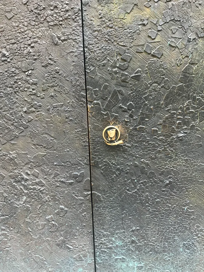 Anielskie Drzwi — brass door handle and bronze surface texture, Mitoraj 2009