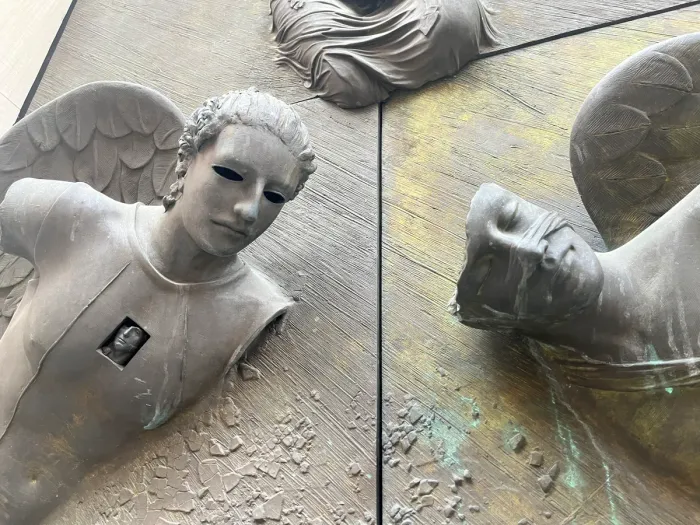 Anielskie Drzwi — angel face with hollow eyes, Mitoraj bronze door detail